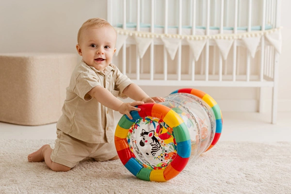 DUMEL Dmuchany roler do nauki raczkowania 44cm grzechoczące piłeczki